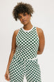 A woman wearing a green checkered tank top with a built-in bra, designed for golfing or casual wear.