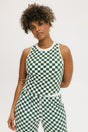 A woman wearing a green checkered tank top with a built-in bra, designed for golfing or casual wear.