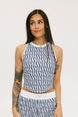 A woman wearing a blue geometric patterned tank top with a built-in bra, paired with matching pants.