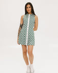 A model wearing a green and white checkered sleeveless dress with a zipper down the front and pockets.