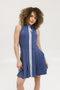 A woman in an indigo sleeveless knee-length dress with a top-to-bottom zipper.