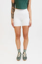 A person wearing white shorts and green shoes.