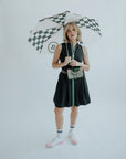 Girl holding a checkered black and cream umbrella