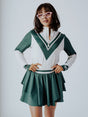 A person wearing a green and pink Micky Quarter Zip golf shirt paired with a green skirt.