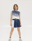 A model wearing an indigo and white intarsia mock neck, sleeveless Fore Sweater.