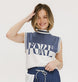 A model wearing an indigo and white intarsia mock neck, sleeveless Fore Sweater.