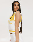 A sleeveless mock-neck sweater with intarsia knit design, featuring horizontal yellow and white stripes and the word 'FORE' printed across the chest.