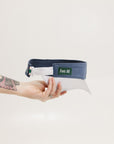 A hand holding a visor with 'FORE' written in bold letters on the front and 'FORE ALL' on the back, against a white background.