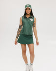 A green baseball cap with pinstripe detailing and an embroidered logo worn by a model against a white background.
