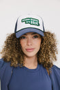 A model wearing an indigo and white hat with the text 'DOUBLE BOGEYS ARE HOT' on the front