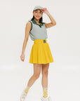 A woman wearing a green seersucker baseball cap with 'Chasing Balls' text embroidered on it and an oversized bow at the back.