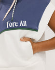 A person wearing a sleeveless hoodie with colorblocking and branding on the chest, in indigo, white, and green colors.