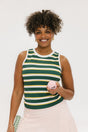 A woman smiling and wearing a sleeveless tank top with green and yellow stripes and a solid white neckline and armholes.