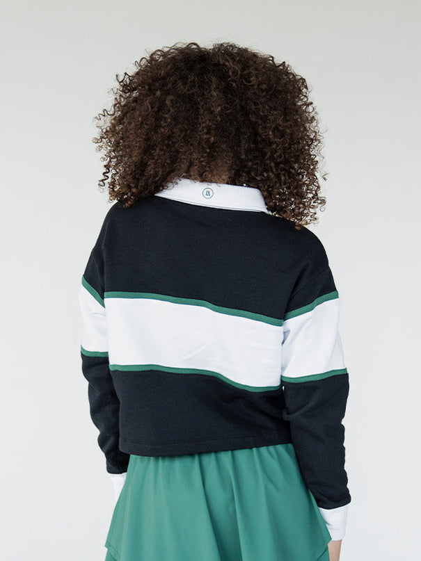 Person wearing a striped sweater and green skirt on a plain background