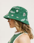 A person wearing a green bucket hat with white embroidered icons.