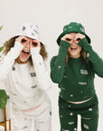 Two models wearing matching icon outfits both in green and white