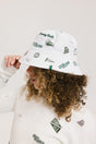 A person wearing a white bucket hat with green embroidered icons.