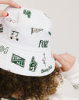 A person wearing a white bucket hat with green embroidered icons.